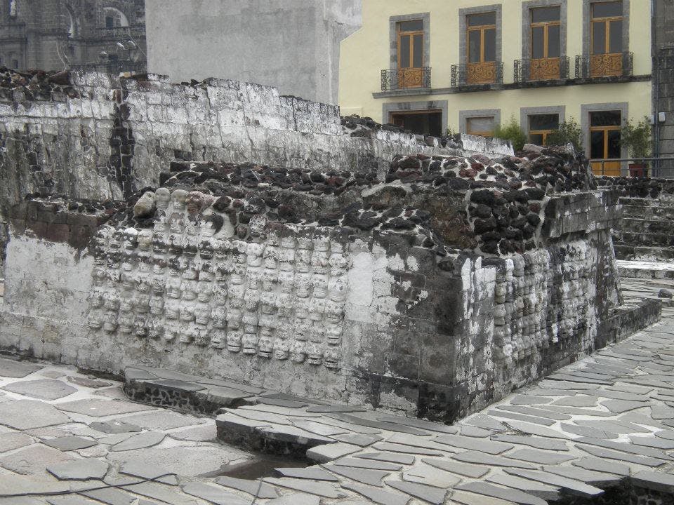  Figure 2. The excavated ruins of a pyramid in the central square with a colonial-era building behind it